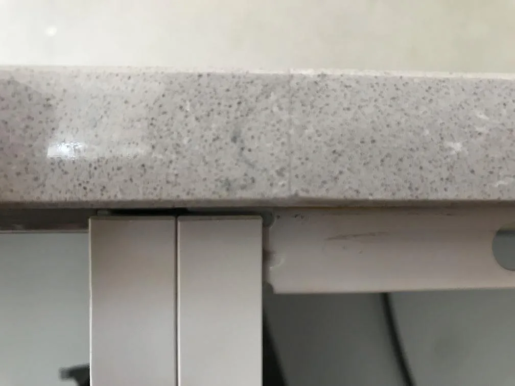 Närbild på den polerade kanten och den melerade ytan på en bänkskiva i Silestone Royal Reef i Karlskrona.