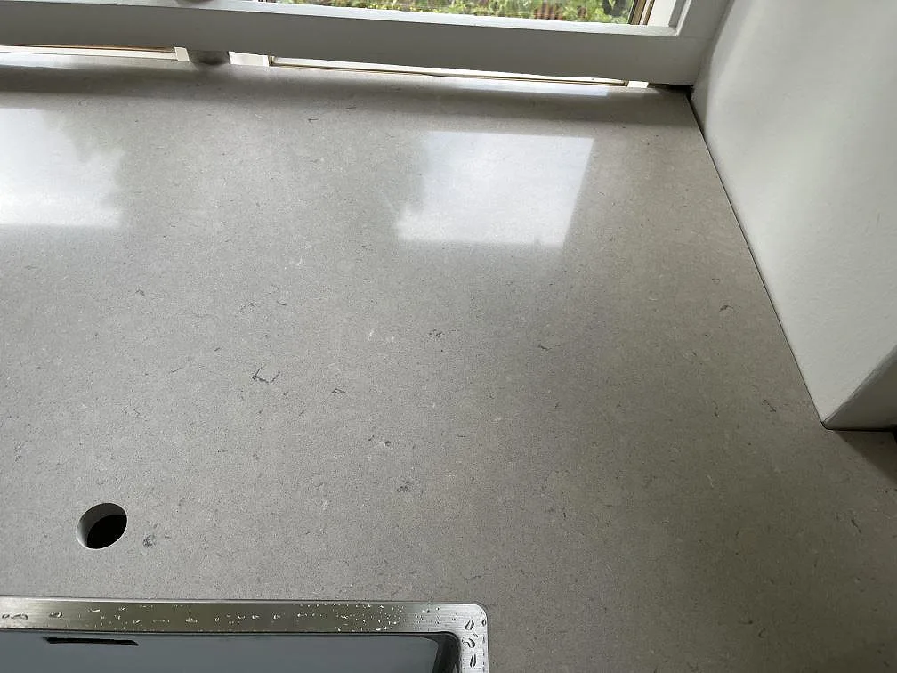 Sandbeige Silestone Royal Reef bänkskiva i polerad finish vid fönster, med borrat hål för blandare och underlimmad diskho, i ett kök i København N.