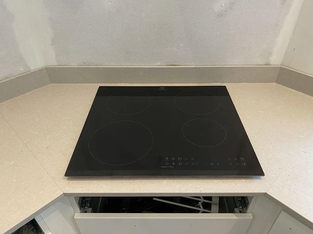 Infälld induktionshäll med fyra zoner i en matt bänkskiva i Silestone Royal Reef i ett kök i Kristianstad.