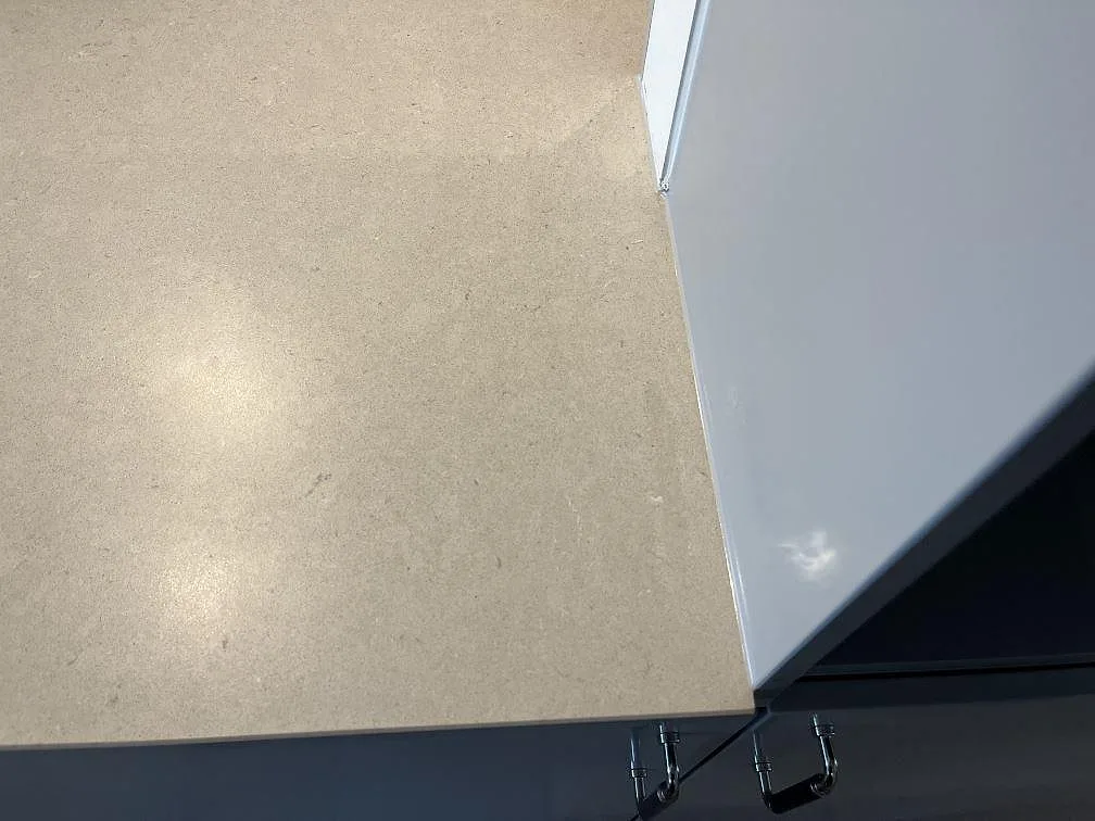 Kantdetalj på köksbänkskiva i Silestone Royal Reef komposit intill vita köksstommar i Limhamn.