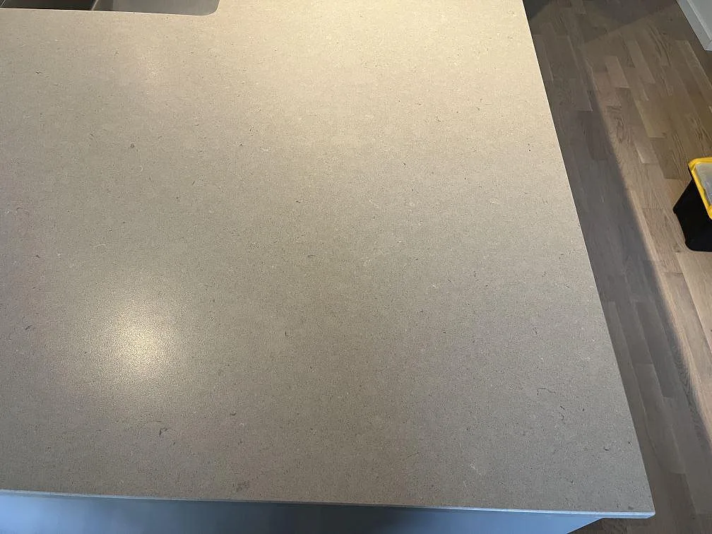 Detalj av ljus beige Silestone Royal Reef komposit över köksö med synlig stenstruktur i Limhamn.