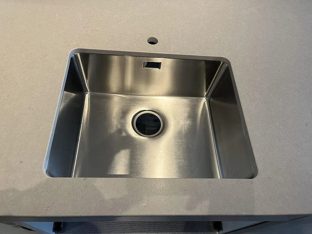 Närbild på rostfri diskho i köksbänkskiva av Silestone Royal Reef komposit i Limhamn.