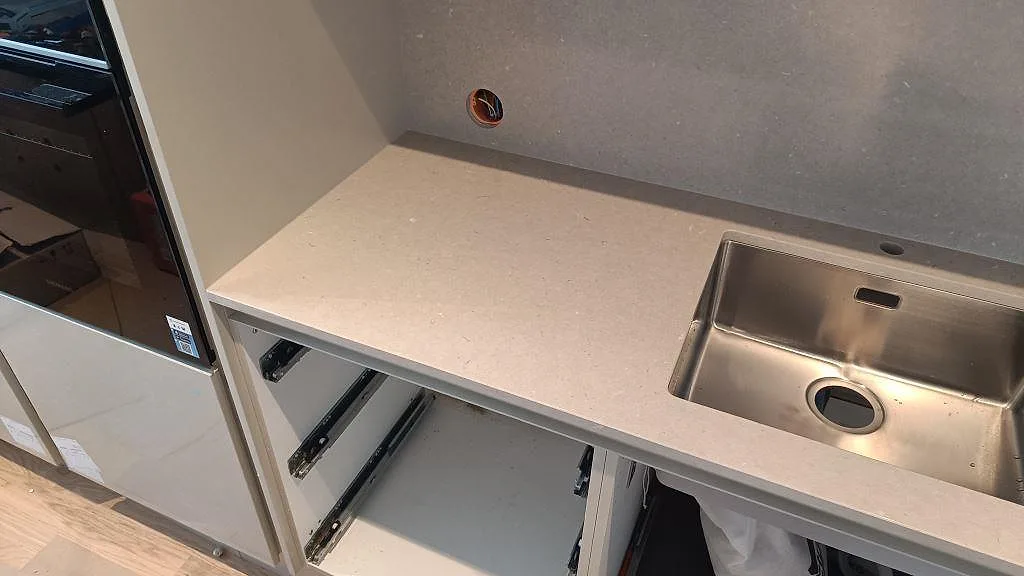 Sned vy över polerad Silestone Royal Reef på bänkrad med öppna stommar och rostfri diskho i Limhamn.