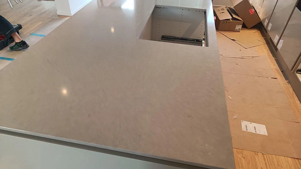 Närbild av polerad Silestone Royal Reef på köksö med rektangulärt urtag och synligt gråbeige mineralmönster i Limhamn.