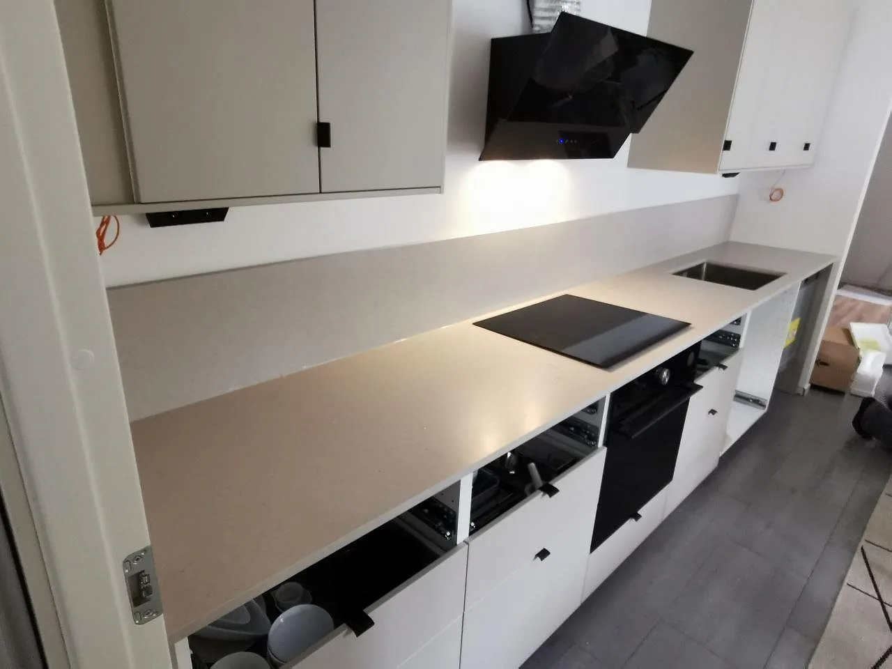 Köksbänkskiva i greige Silestone Royal Reef, matt Mocka, med spishäll, underlimmad rostfri diskho och stänkskydd i ett kök i Lomma.