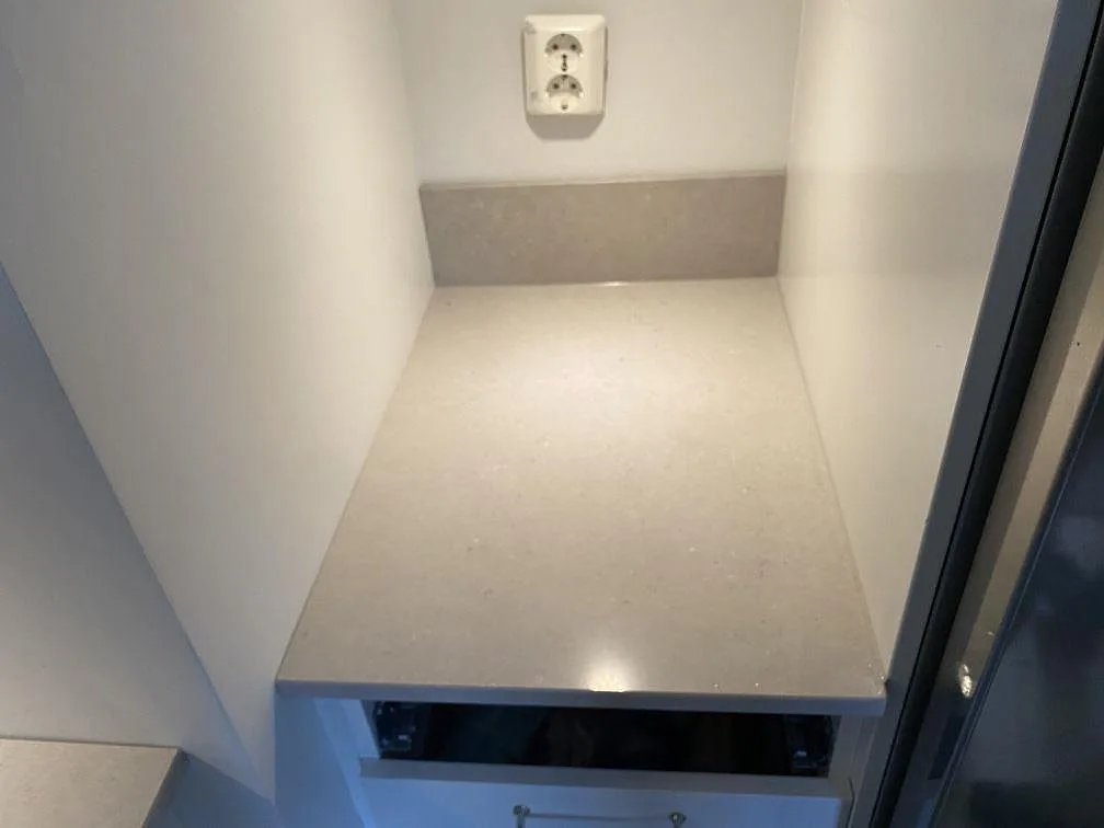 Kort köksbänk i polerad Silestone Royal Reef med matchande stänkskydd och vägguttag i Lund.
