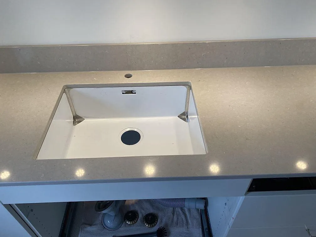 Närbild på polerad Silestone Royal Reef som köksbänkskiva med diskho och uppvikt stänkskydd i Lund.