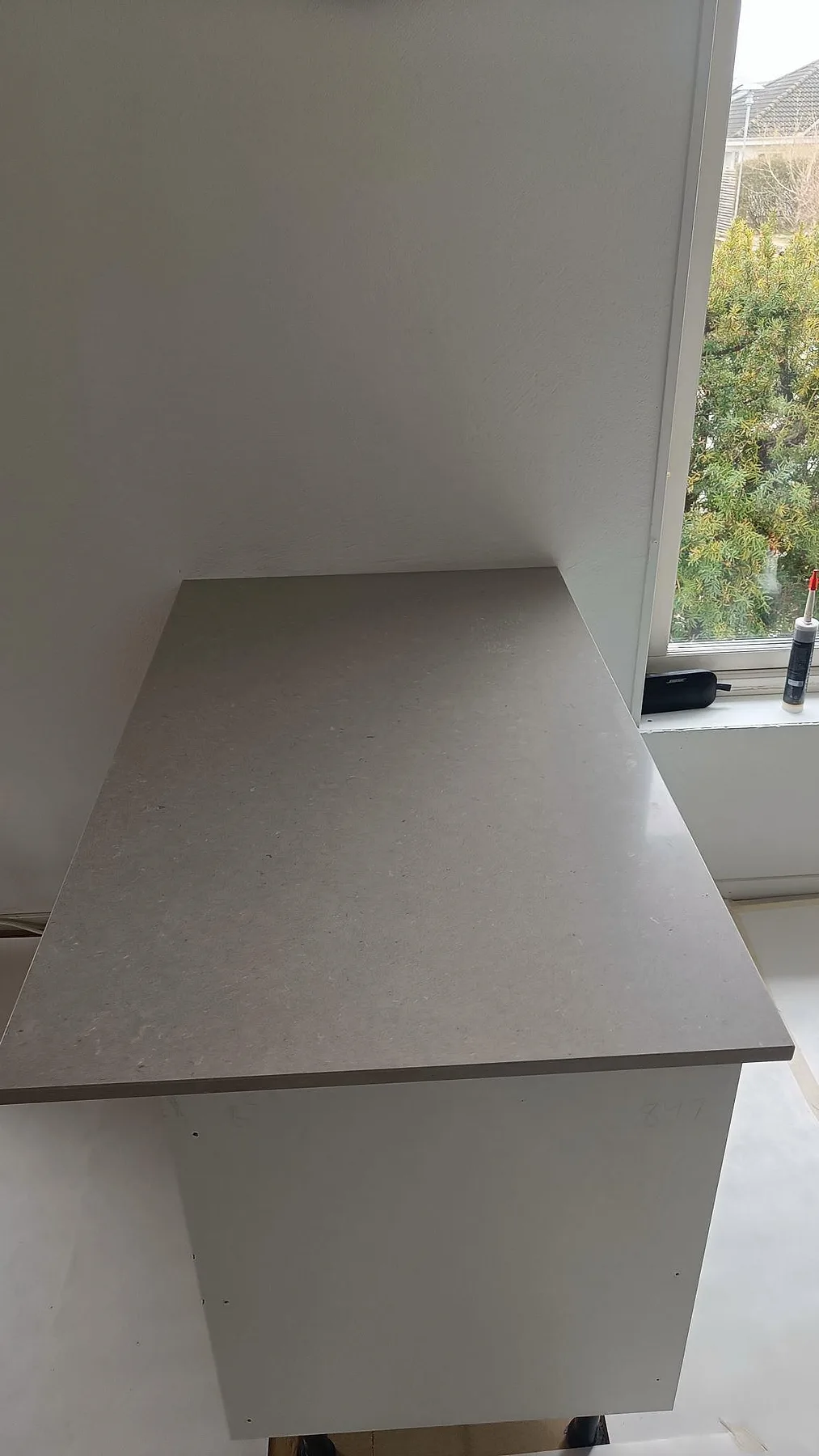 Bänkskiva vid fönster i polerad Silestone Royal Reef, monterad som del av ett ljust kök i Malmö.