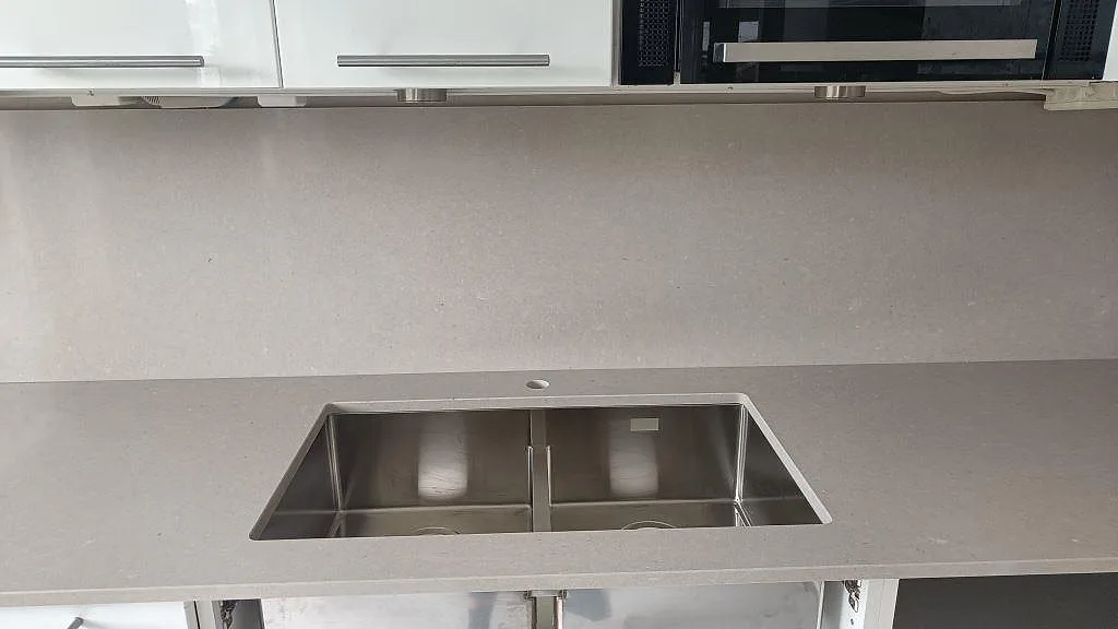 Underlimmad dubbel rostfri diskho i polerad Silestone Royal Reef, monterad i en köksbänkskiva i Malmö.