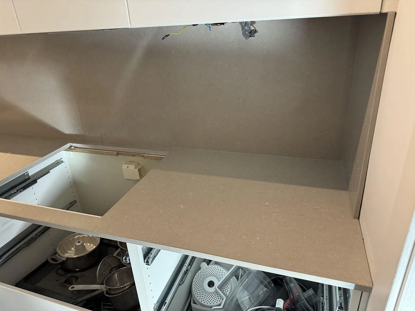 Köksbänkskiva i polerad Silestone Royal Reef, kvartskomposit, monterad på öppna köksstommar med grå väggbeklädnad i Malmö.