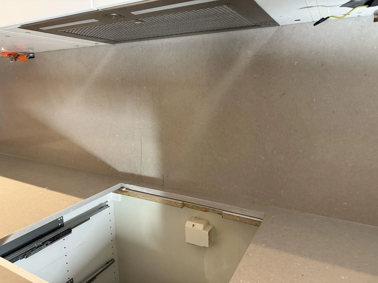 Polerad Silestone Royal Reef, kvartskomposit, som bänkskiva och väggbeklädnad under överskåp i ett kök under montering i Malmö.