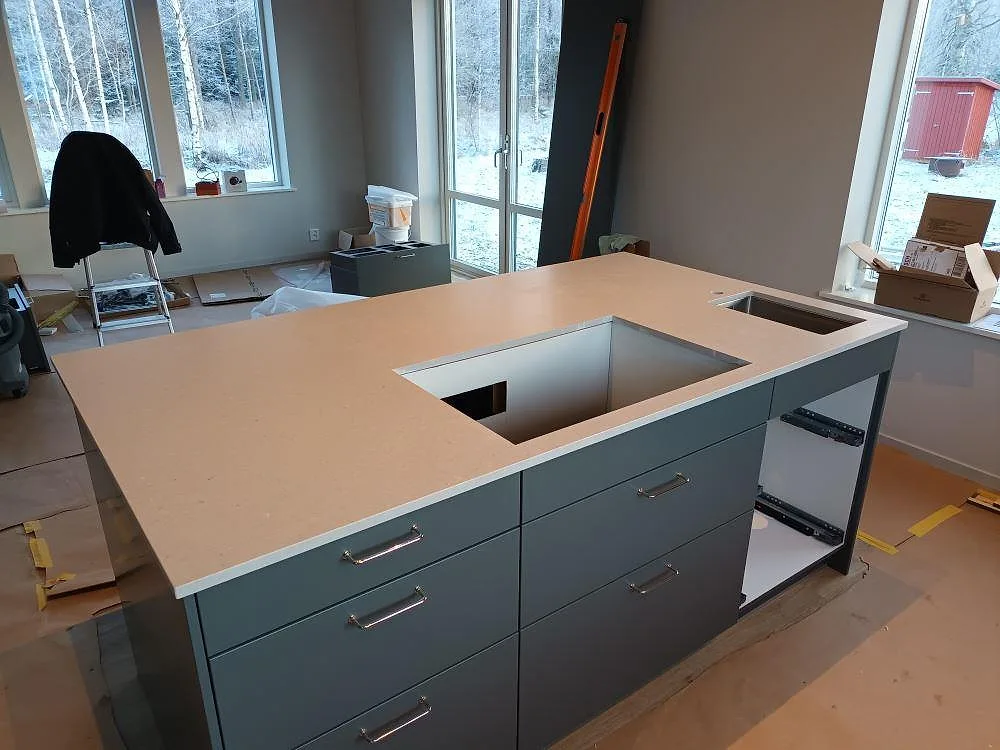Närbild på köksö i Silestone Royal Reef, matt komposit, med stora utskärningar i en pågående köksmontering i Örebro.