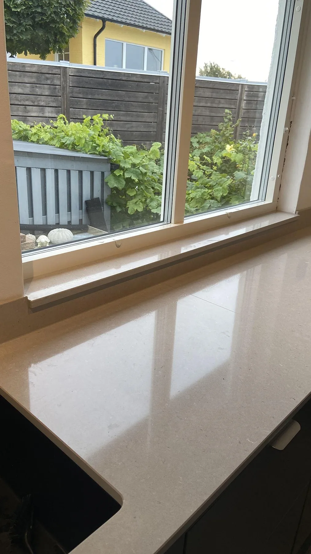 Polerad fönsterbänk i Silestone Royal Reef med mjuk spegling i ljuset i ett kök i Oxie.