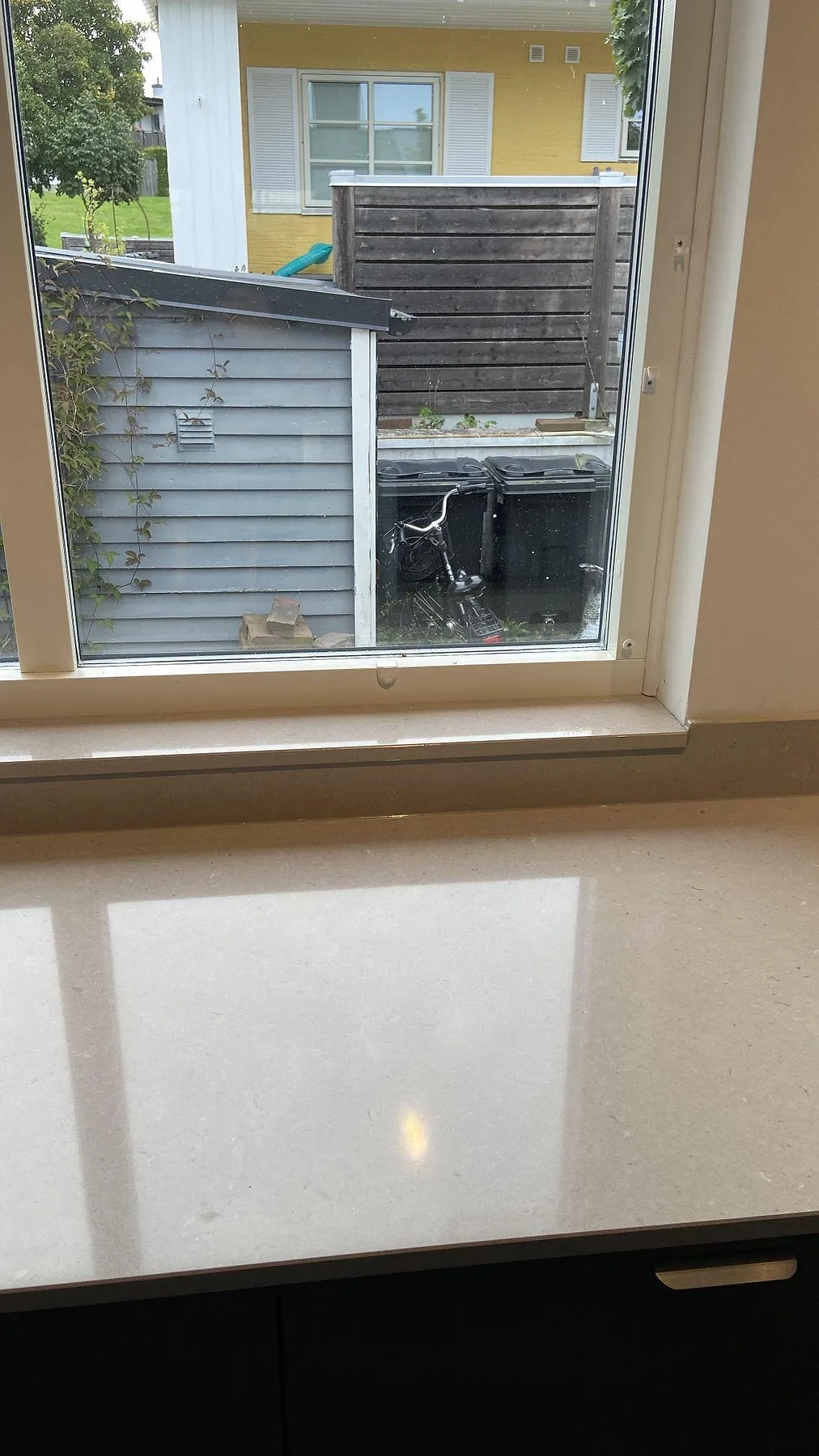 Fönsterbänk i Silestone Royal Reef, beige polerad kvartskomposit, monterad under köksfönstret i Oxie.