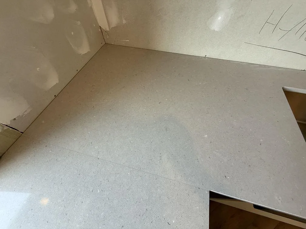 Detalj av hörnpassning och kapad bänkskiva i polerad Silestone Royal Reef under montering i Skänninge.