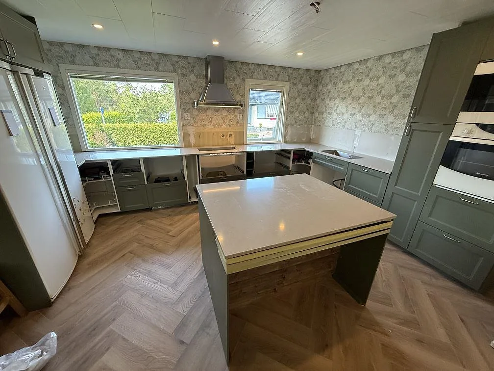 Köksbänkskiva och köksö i polerad Silestone Royal Reef, ljus kvartskomposit monterad i ett kök i Skänninge.