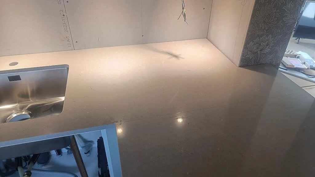 Polerad köksbänkskiva i Silestone Royal Reef med underlimmad rostfri diskho och grå ådring i Skillingaryd.