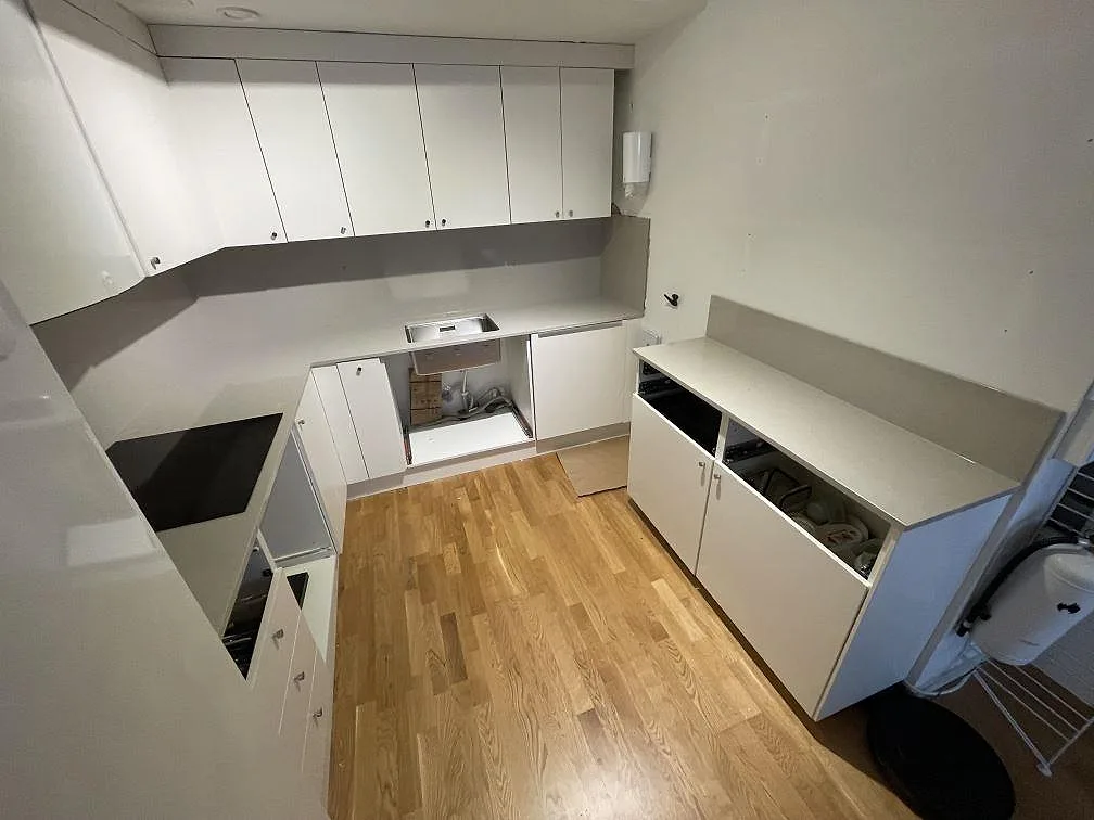 Köksbänkskiva och halvö i beige Silestone Royal Reef i ett kök i Stockholm, fotograferat under montering med öppna stommar och induktionshäll.
