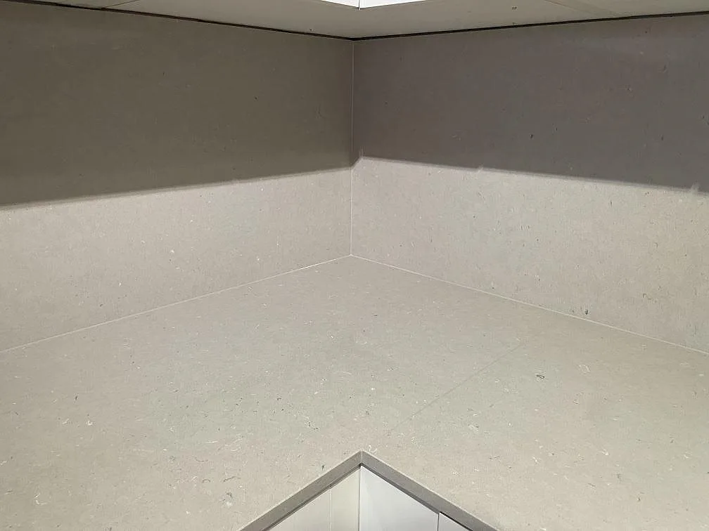 Närbild på den beige Silestone Royal Reef köksbänkskivan och det kontrasterande Coral Clay stänkskyddet i ett kök i Stockholm.