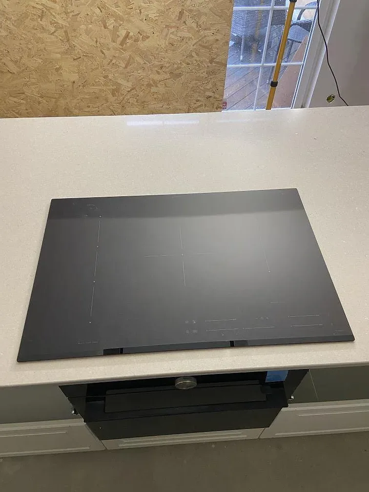 Infälld induktionshäll i en bänkskiva av Silestone Royal Reef i komposit, polerad yta, i ett kök i Tjurkö.