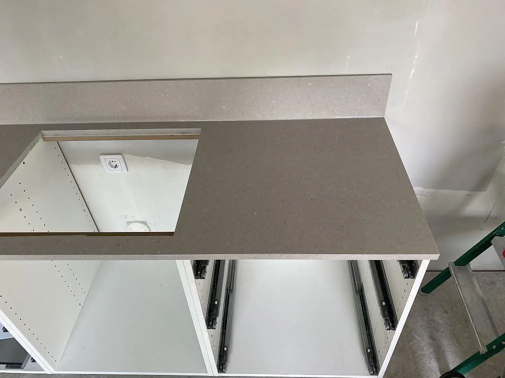 Silestone Royal Reef som ljusgrå kompositbänkskiva på vita köksstommar med stänkkant i Trelleborg.