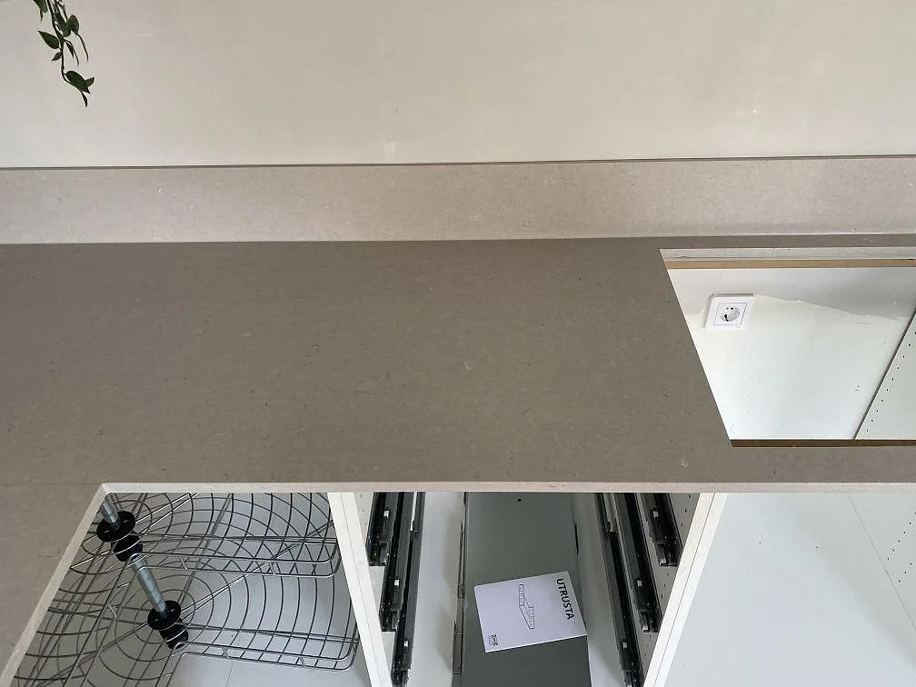 Lång del av polerad Silestone Royal Reef-bänkskiva med hälluttag och stänkkant under montering i Trelleborg.