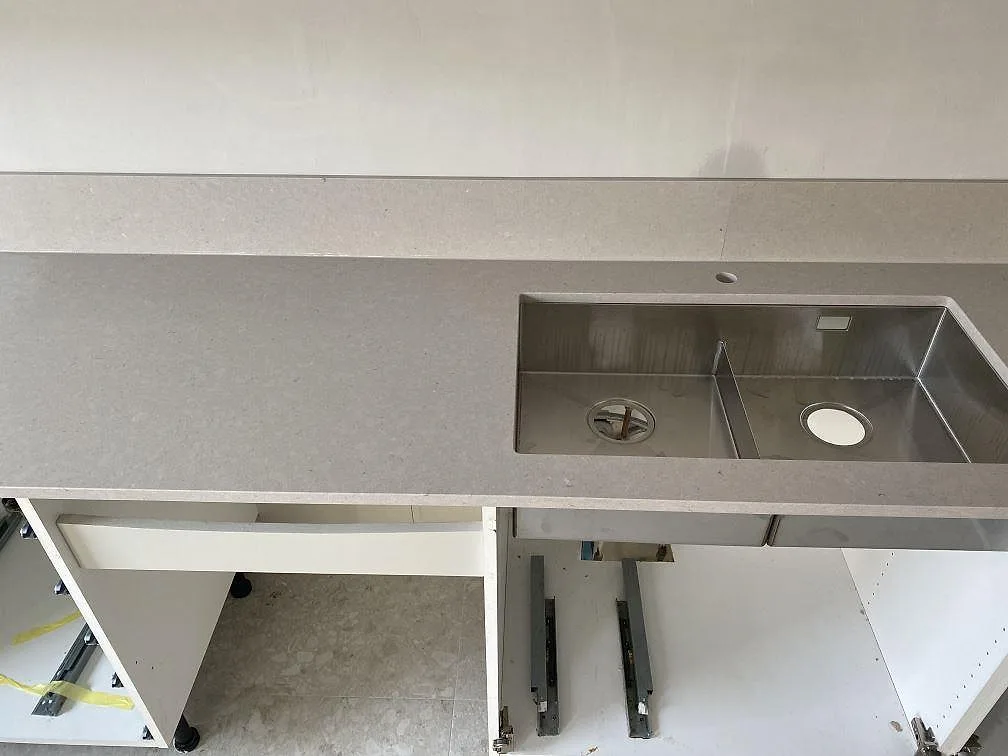 Detalj av köksbänkskiva i Silestone Royal Reef, polerad komposit, med rostfri diskho monterad under stenen i Trelleborg.