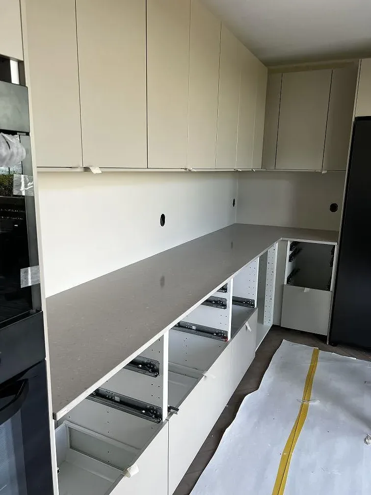 L-formad köksbänkskiva i 20 mm polerad Silestone Royal Reef på vita köksstommar i Trelleborg.