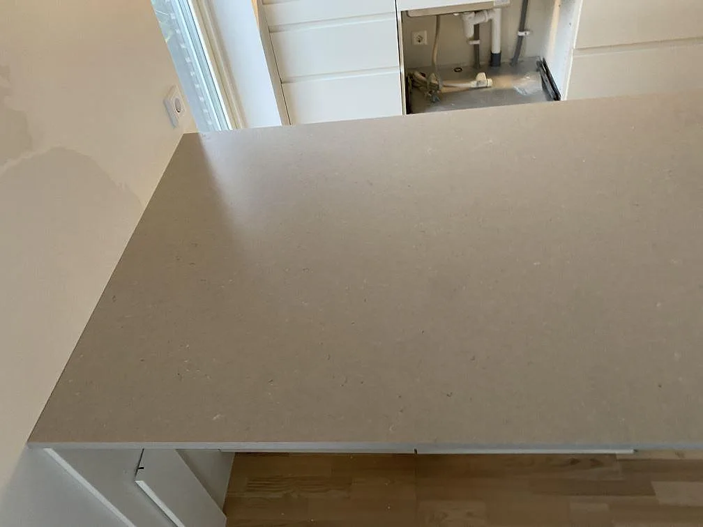 Köksö i Silestone Royal Reef Mocka med synlig rak framkant under montering i Tygelsjö.