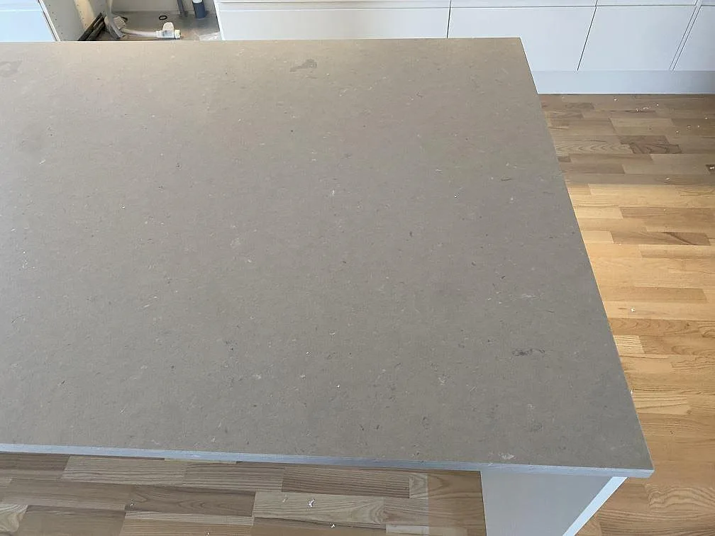 Köksö i Silestone Royal Reef i mocka, som visar den matta beige stenens diskreta ådring, i ett kök i Tygelsjö.