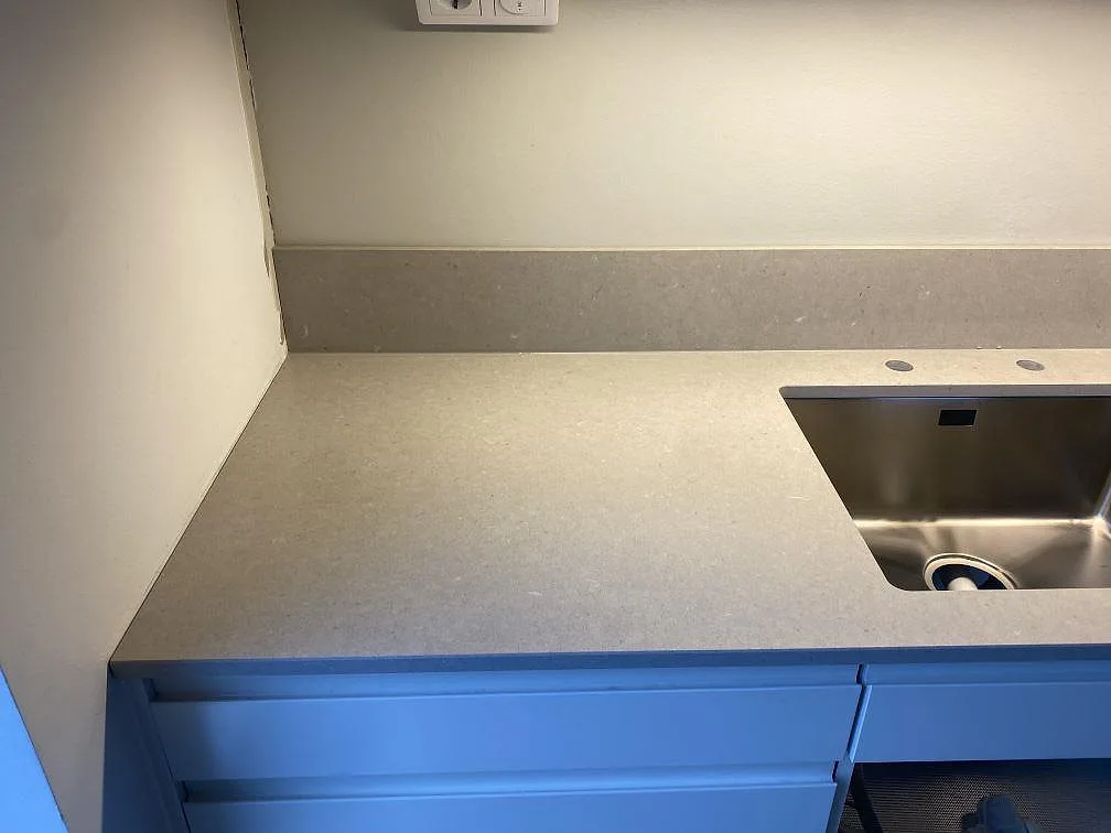 Köksbänkskiva i Silestone Royal Reef med underlimmad rostfri diskho och uppvikt stänkkant i ett kök i Tygelsjö.