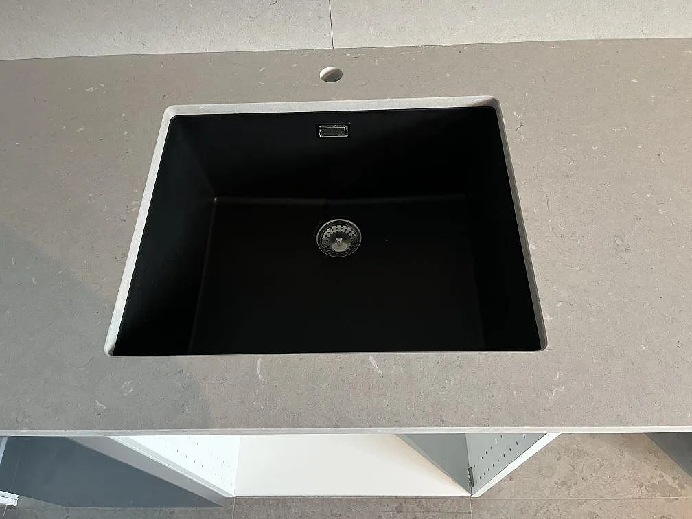 Underlimmad svart diskho i matt Silestone Royal Reef komposit på köksbänkskiva med blå stommar i Tyresö.