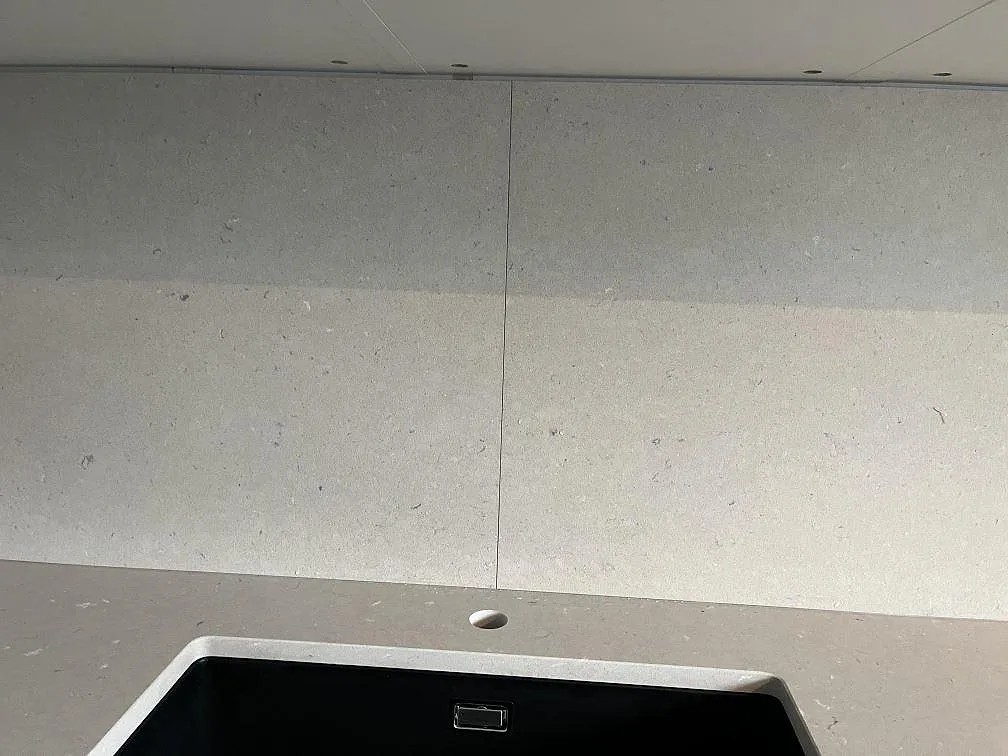 Köksbänkskiva och stänkskydd i matt Silestone Royal Reef komposit vid svart underlimmad diskho i Tyresö.