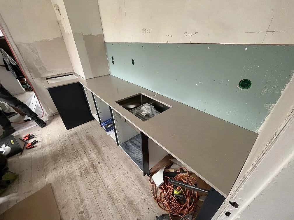 Köksbänkskiva i grågrön Silestone Royal Reef, polerad komposit, med synligt urtag i ett kök i Tyresö.