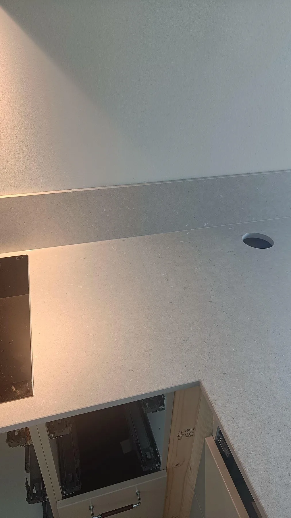 Detaljbild av matt Silestone Royal Reef med stänkkant, hällkant och rund kabelgenomföring i köket i Uddevalla.