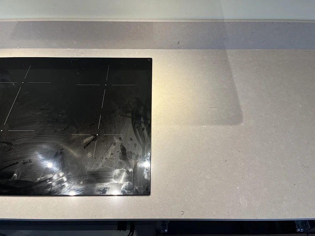 Induktionshäll infälld i en beige Silestone Royal Reef bänkskiva sedd ovanifrån i ett kök i Växjö.