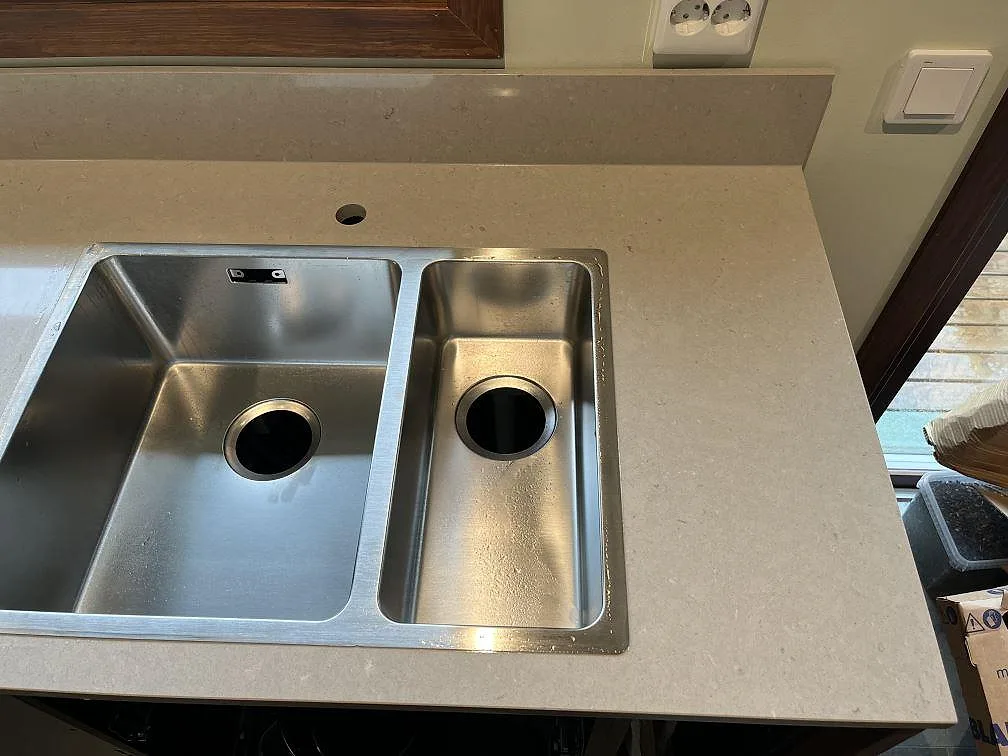 Underlimmad rostfri diskho med två sektioner i en polerad Silestone Royal Reef bänkskiva i Växjö.