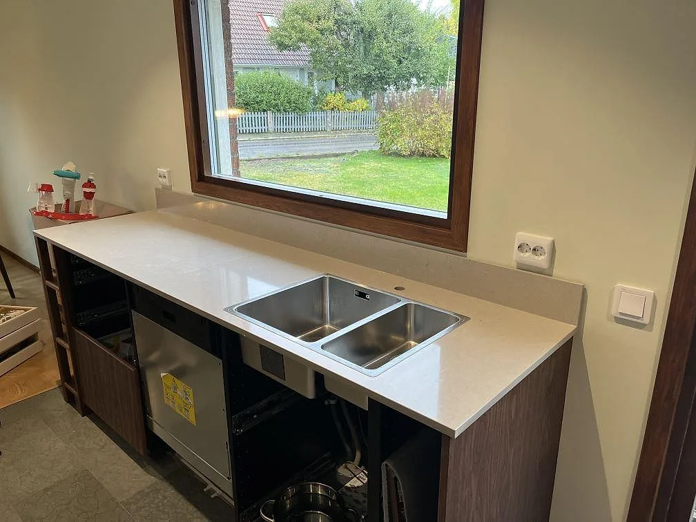 Polerad Silestone Royal Reef bänkskiva med underlimmad rostfri diskho under ett fönster i ett kök i Växjö.