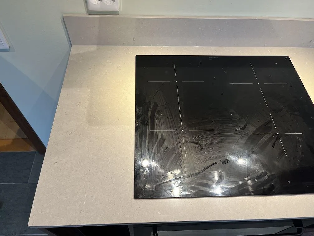 Infälld induktionshäll i en polerad Silestone Royal Reef köksbänkskiva i ett kök i Växjö.