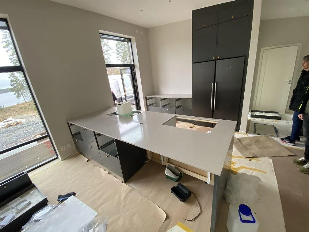 Köksö i ljus Silestone Royal Reef, polerad, nymonterad i ett kök med mörkgrå luckor och sjöutsikt i Vaggeryd.