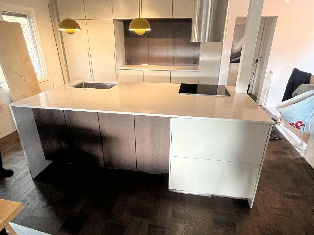 Köksbänkskiva i greige Silestone Royal Reef, polerad komposit, med diskho och häll på en köksö i Vallentuna.
