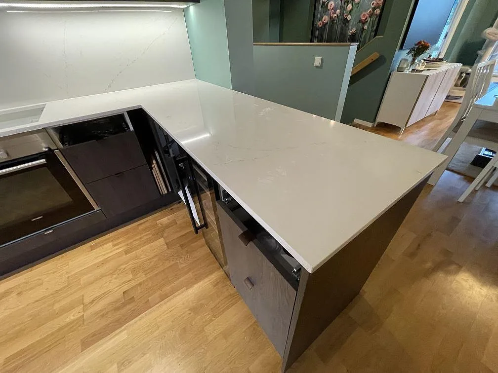 Polerad Silestone Siberian frost på kökshalvö med ljus ådring och blank yta i ett kök under montering i Bromma.