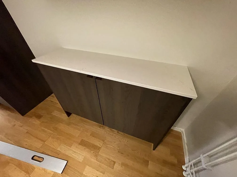 Extra bänkskiva i polerad Silestone Siberian frost över mörka skåp, monterad mot vägg i Bromma.