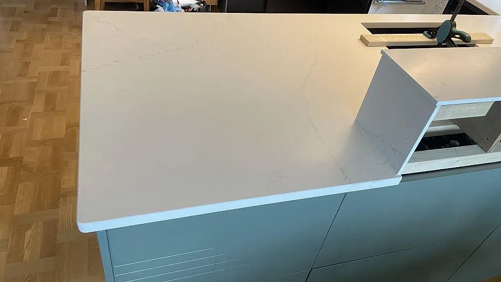 Närbild av matt Silestone Siberian frost på köksö med ljus ådring, rak framkant och öppna köksstommar i Jönköping.