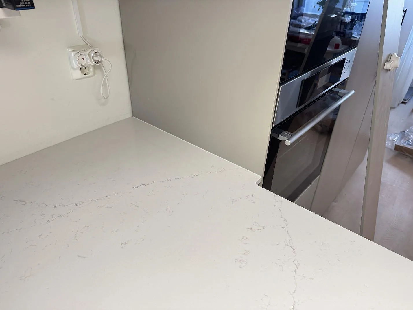 Närbild på polerad Silestone Siberian frost vid en större köksbänk med ljus kvartskompositådring i Limhamn.
