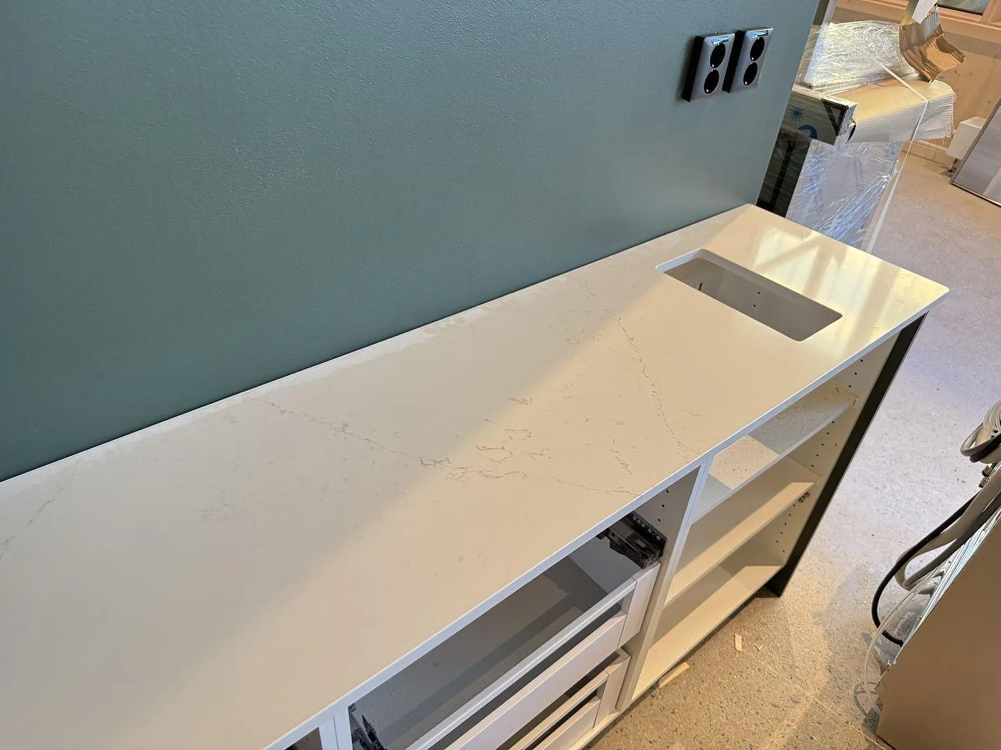 Köksbänkskiva i polerad Silestone Siberian frost med rektangulärt urtag och öppna vita stommar i Malmö.