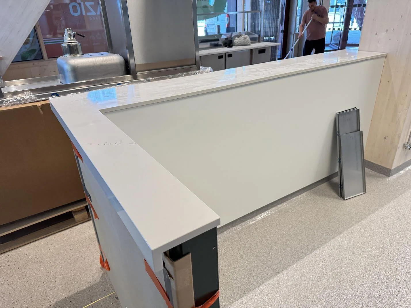 Vinklad bänkyta i polerad Silestone Siberian frost i ett kök under montering i Malmö, med vit front och synlig ljus ådring.