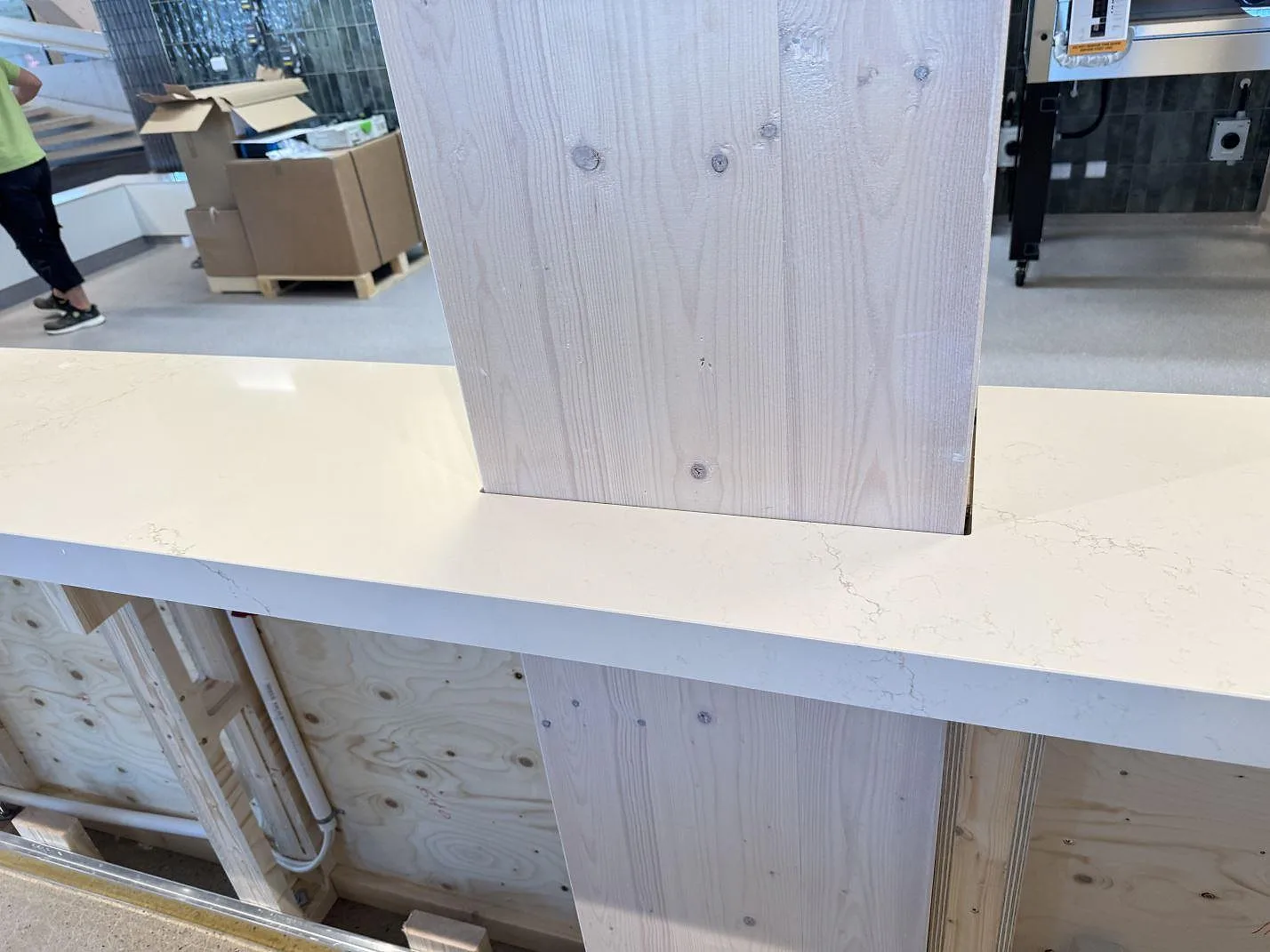 Detalj av polerad Silestone Siberian frost runt en träpelare, med ljus kvartskomposityta under montering i Malmö.