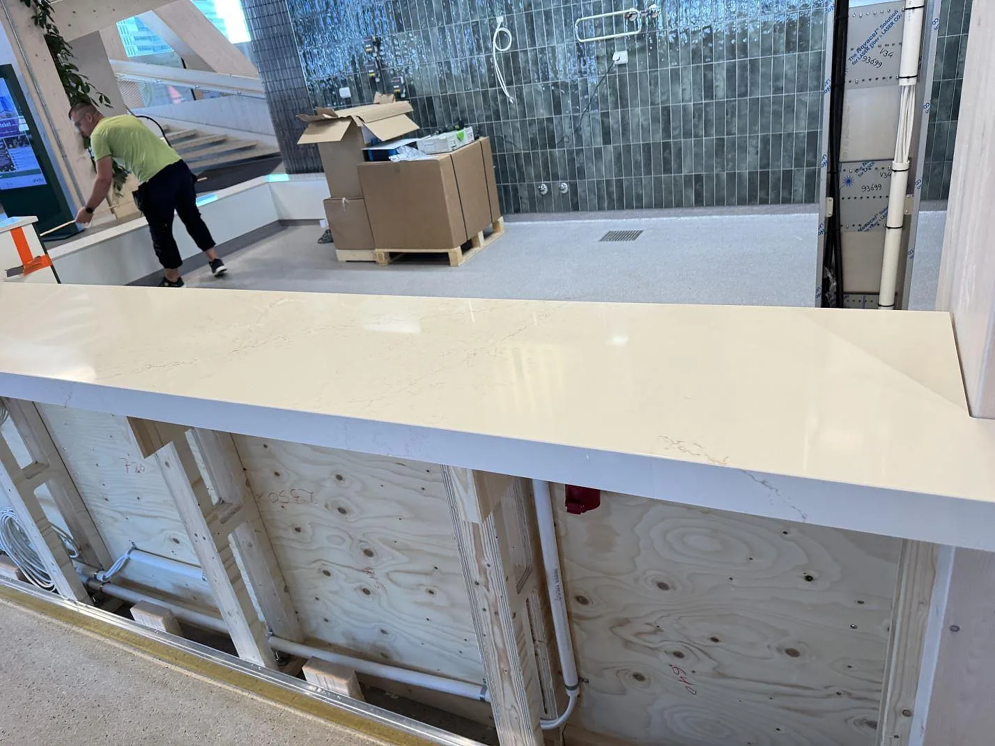 Lång bänkskiva i polerad Silestone Siberian frost med grå ådring, monterad över öppna trästommar i Malmö.