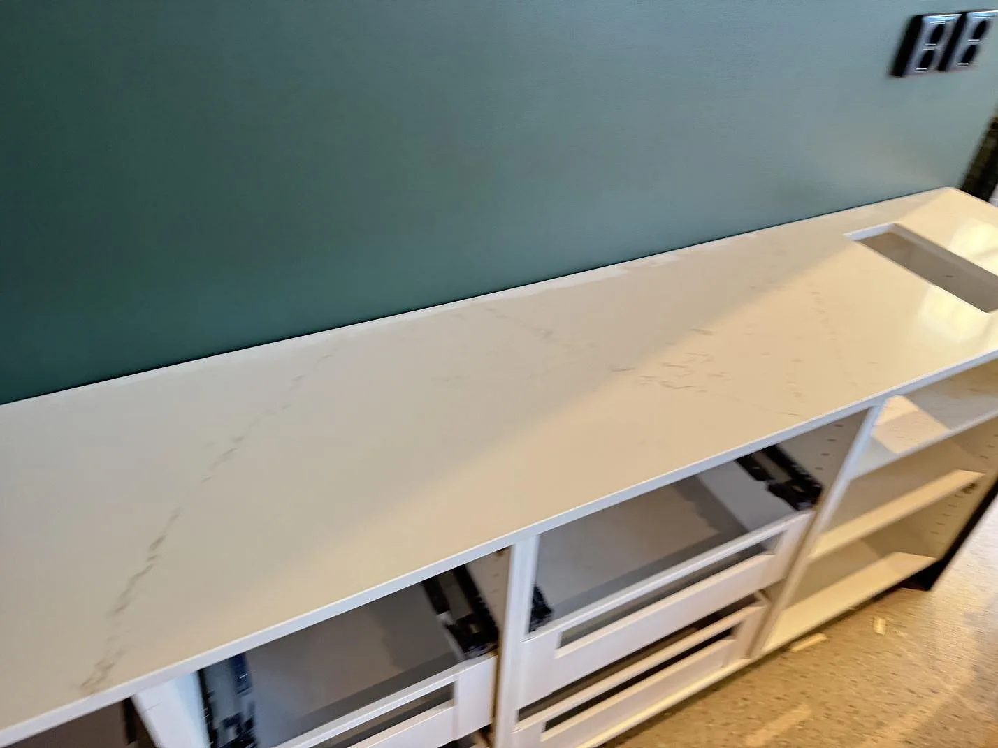 Lång väggmonterad köksbänkskiva i polerad Silestone Siberian frost med diskret grå ådring och öppna stommar i Malmö.